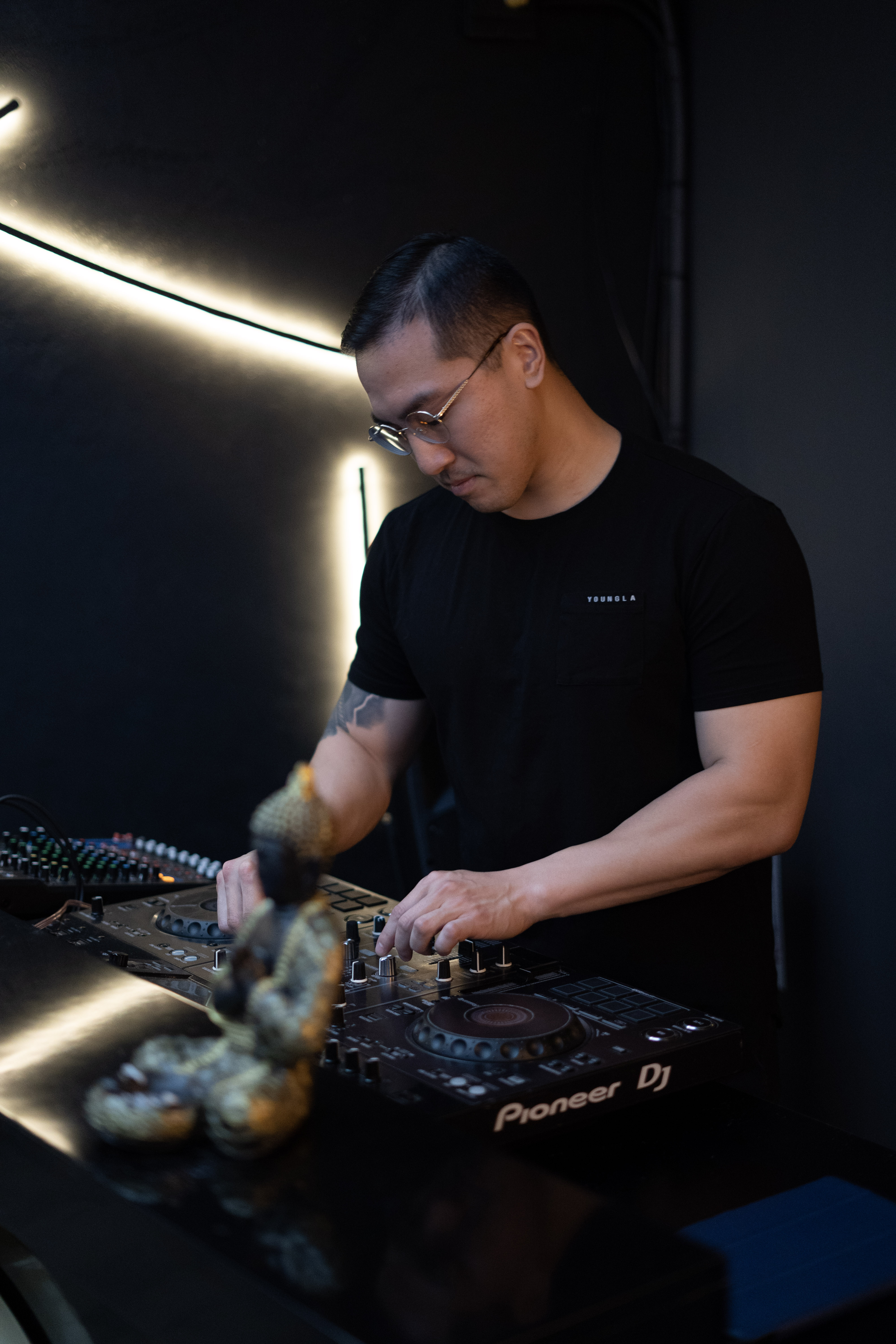 Sean Chi at the Pioneer decks under dark club lighting