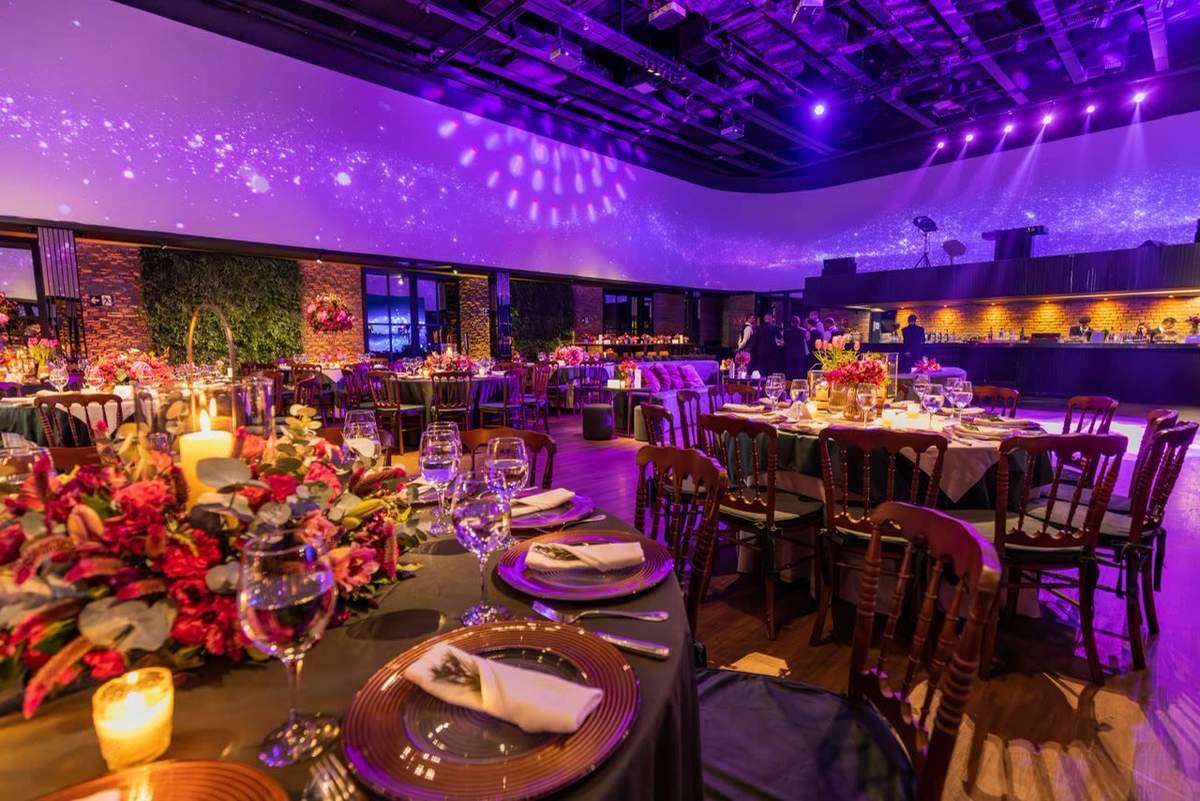 Reception room washed in purple uplighting with a starry ceiling